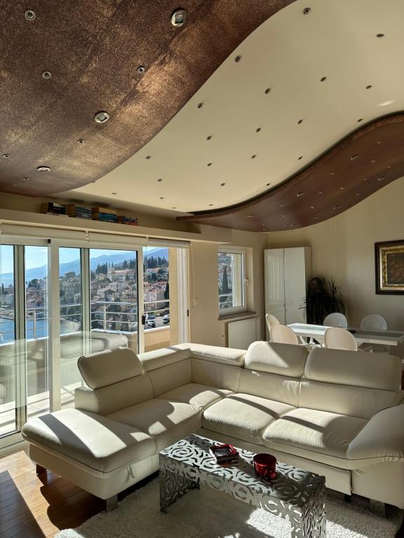 uma sala de estar com um sofá e uma mesa em Villa Dinka VIP apartmani em Opatija