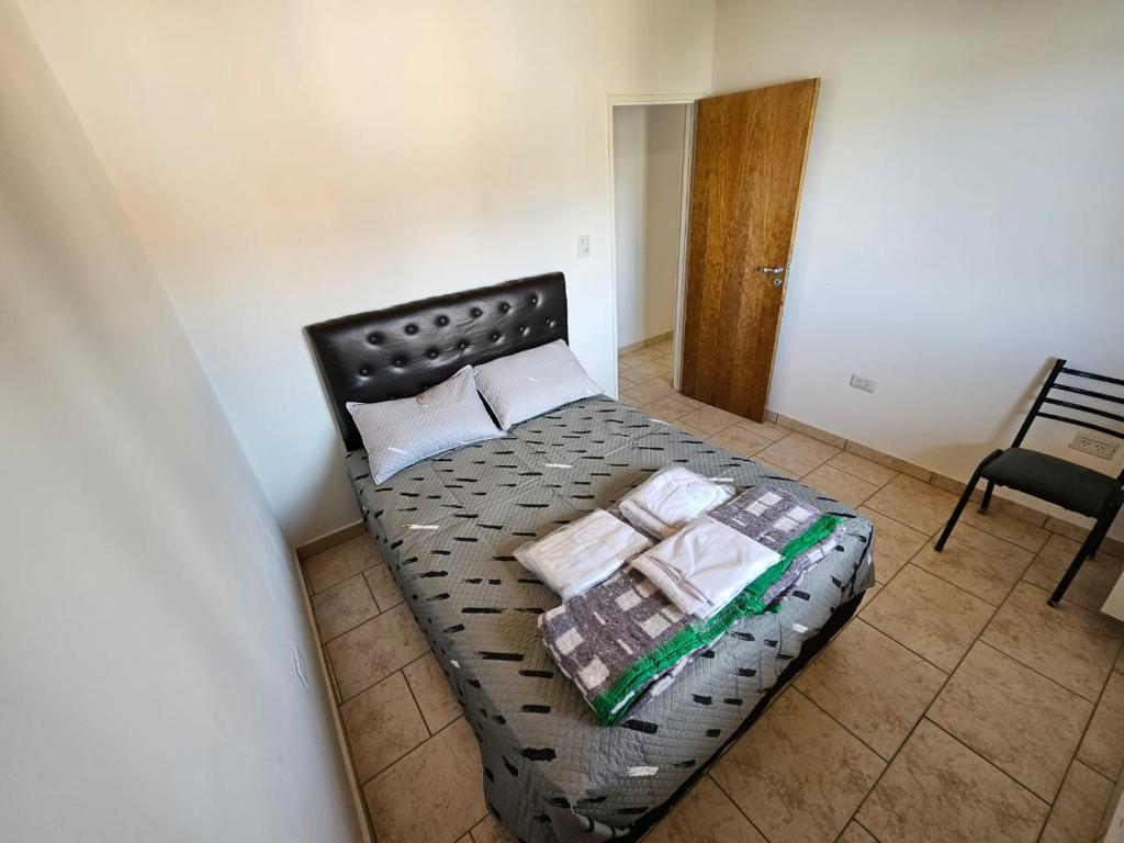 Cette chambre comprend un petit lit et une chaise. dans l'établissement La Juanita, à Junín de los Andes