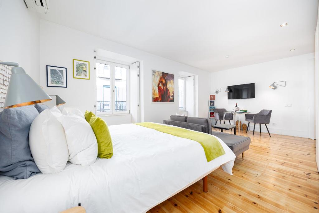 a white bedroom with a large bed and a living room at Boutique Apartment in the Heart of Lisbon ! Lemonn B in Lisbon