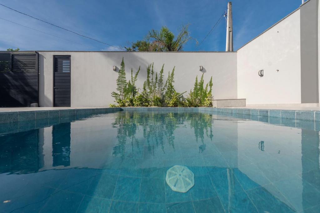 a swimming pool in front of a white building at Alto padrão piscina aquecida em Balneário Camboriú in Balneário Camboriú