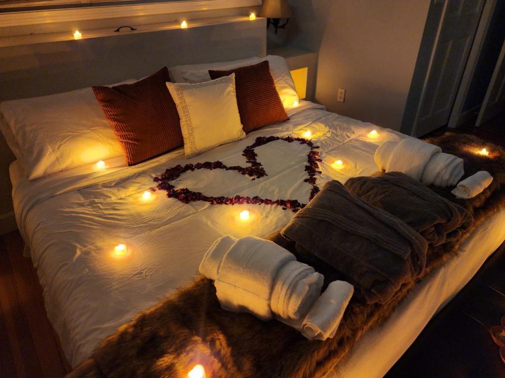 Una cama con un corazón hecho de toallas y luces en Hot Tub, Electric Bikes, Solo Stove, Projector, Smores, en Marblehead