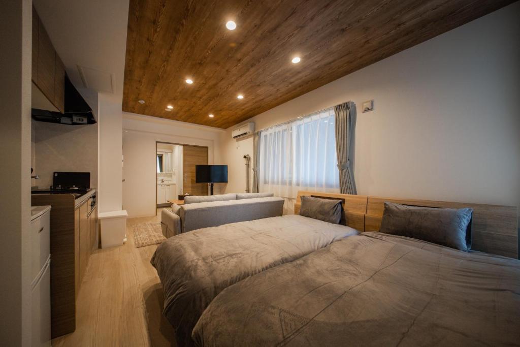 a bedroom with two beds and a television in it at ASPEN【2min from Asahikawa sta】 in Asahikawa