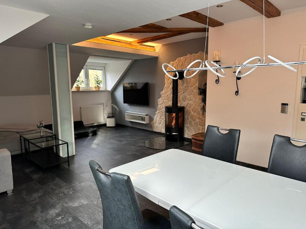 een kamer met een tafel en stoelen en een open haard bij Ferienwohnung Parkblick in Bad Elster