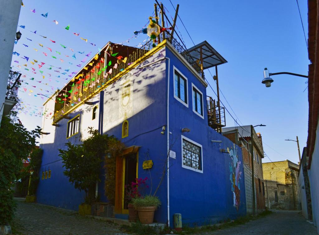 een blauw-wit gebouw met vlaggen erop bij Posada del Fraile in Tepotzotlán