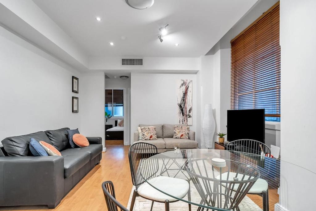 - un salon avec un canapé, une table et des chaises dans l'établissement Cliveden - A Heritage Hideaway with Rooftop Pool, à Sydney