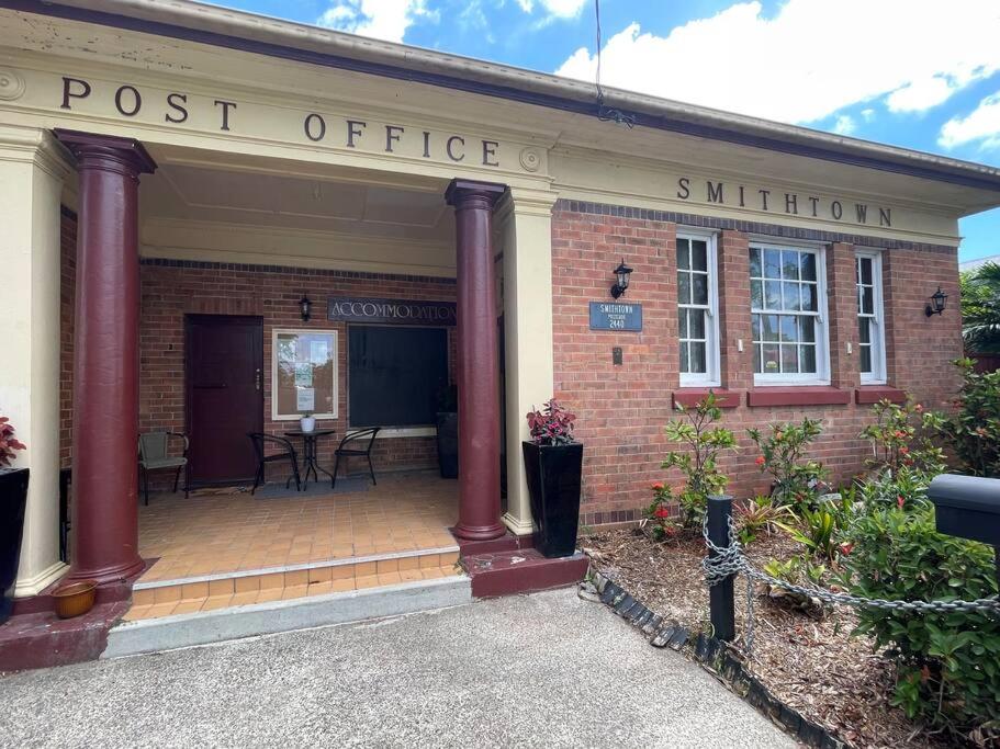 a post office with a sign on a brick building at Post Office Boutique Accommodation in Hat Head