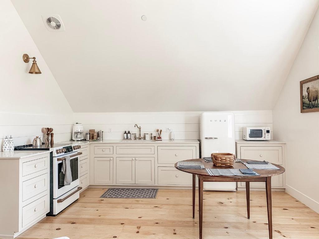 a kitchen with white appliances and a table at Homestead Barn Loft in Sonora