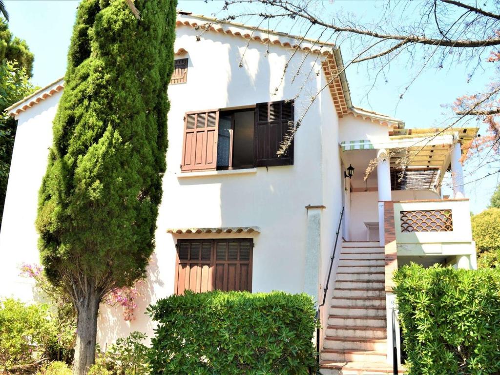 une maison blanche avec des escaliers et une fenêtre dans l'établissement Appartement 2 pièces avec terrasse, proche plage et centre-ville à Cavalaire-sur-Mer, parking inclus - FR-1-226B-19, à Cavalaire-sur-Mer