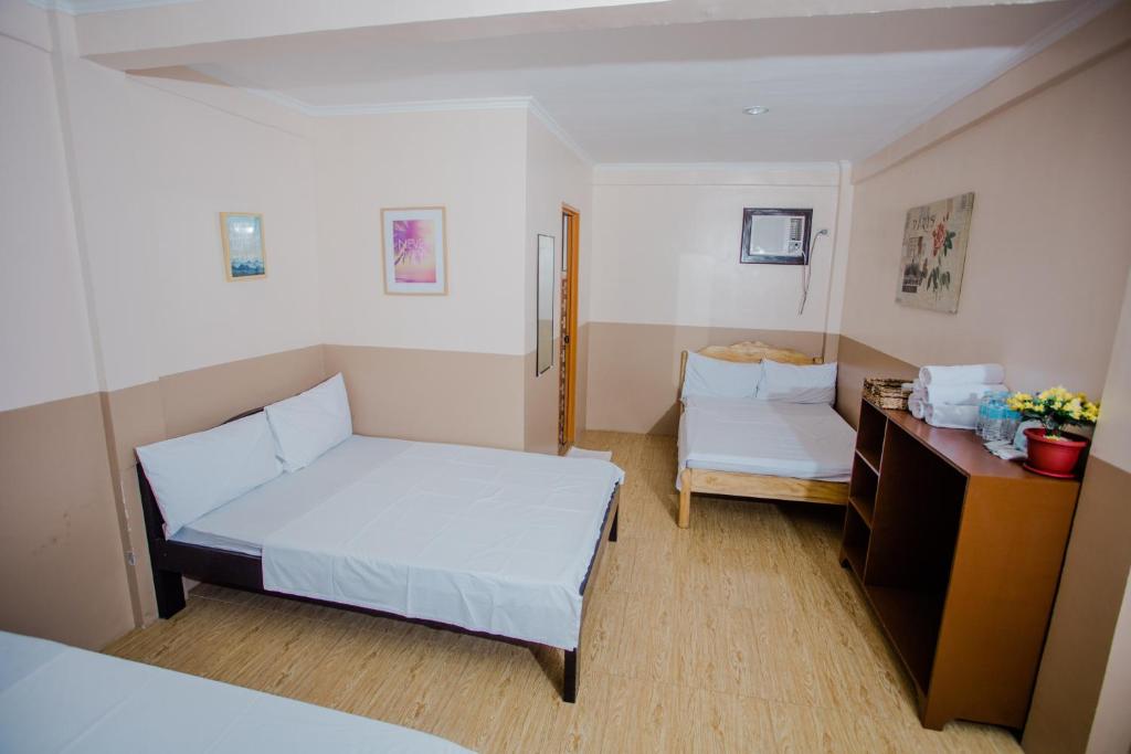Kleines Zimmer mit einem Bett und einem Schreibtisch. in der Unterkunft Durhan White Beach Resort in Tabuelan