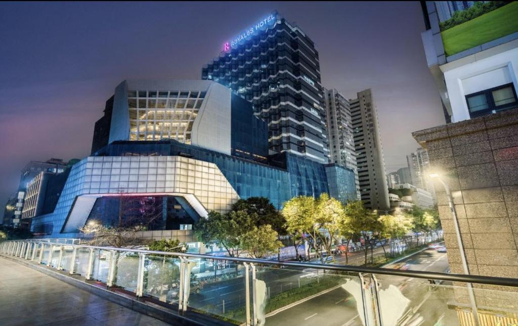 un grand bâtiment en verre dans une ville la nuit dans l'établissement R Royalss Hotel, Chengdu Chunxi Road Taikooli Tianfu, à Chengdu