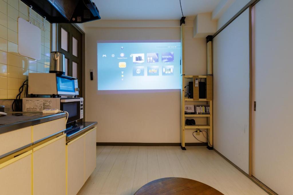 Zimmer mit einer Leinwand in der Küche in der Unterkunft Aoi home Nipponbashi in Osaka