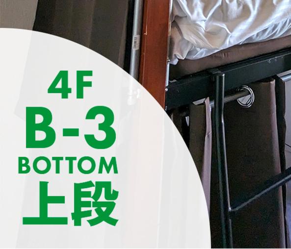 znak siedzący na łóżku piętrowym w obiekcie シェアルーム　イン　那覇エアポート w mieście Naha