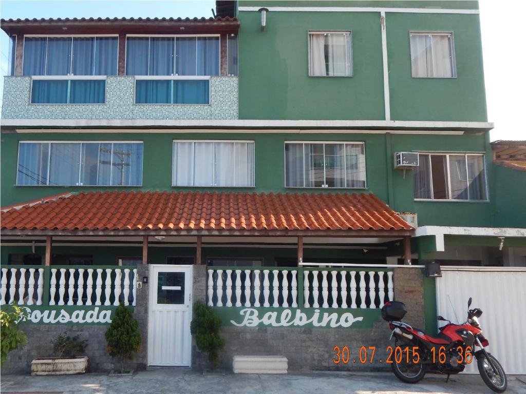 a red motorcycle parked in front of a building at Pousada Balbino in Cabo Frio