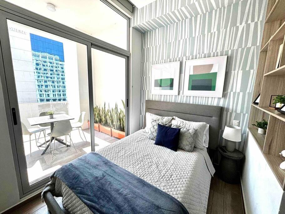 a bedroom with a bed and a balcony with a table at Rincon Moderno cerca aeropuerto in Guatemala