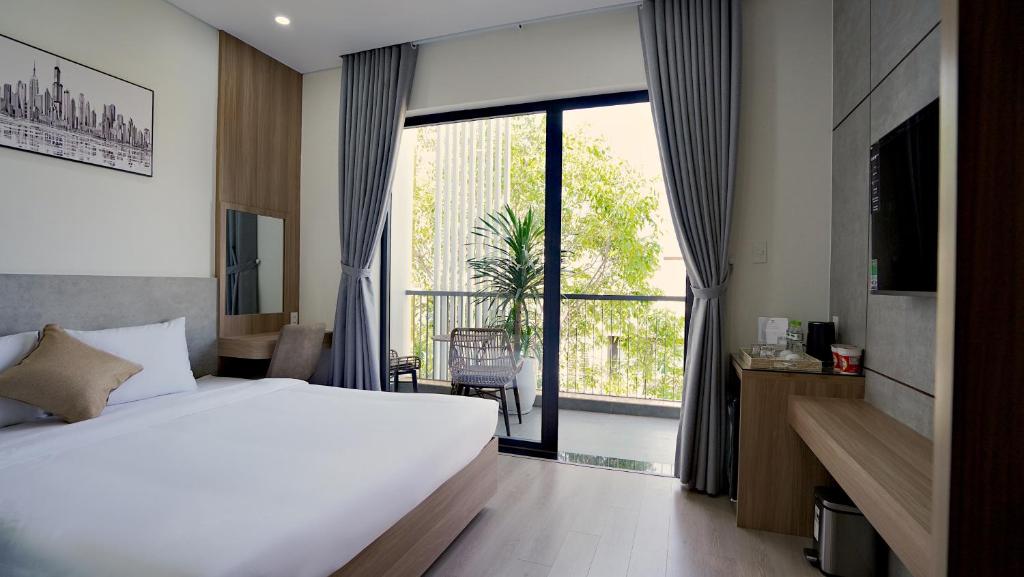 a hotel room with a bed and a large window at Thành Thuý Hotel in Buon Ma Thuot