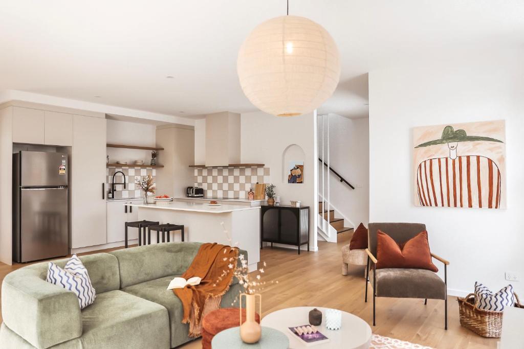 a living room with a couch and a kitchen at Architect Home with View in Central Hobart in Hobart