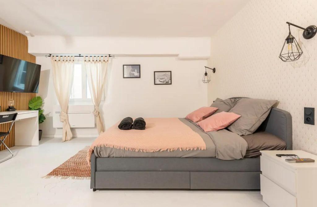 une chambre avec un lit avec deux chaussures dessus dans l'établissement Aux portes du Panier, à Marseille