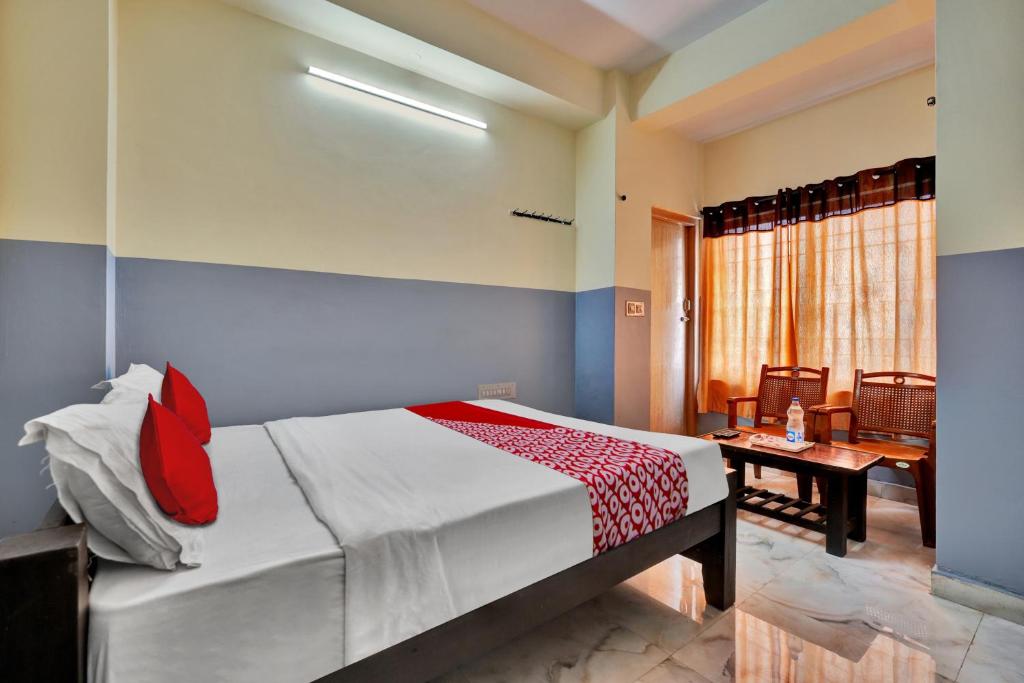a bedroom with a bed and a table in a room at OYO Flagship Jashwanth Residency in Mysore