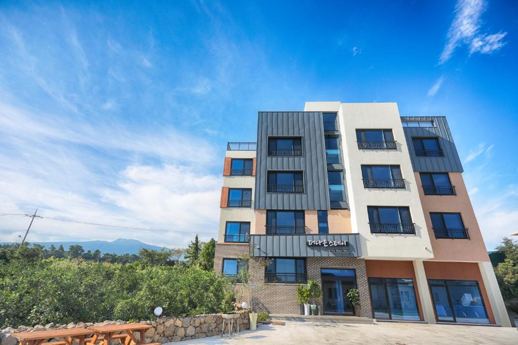 ein hohes Gebäude mit blauem Himmel im Hintergrund in der Unterkunft The Naeun Stay in Seogwipo