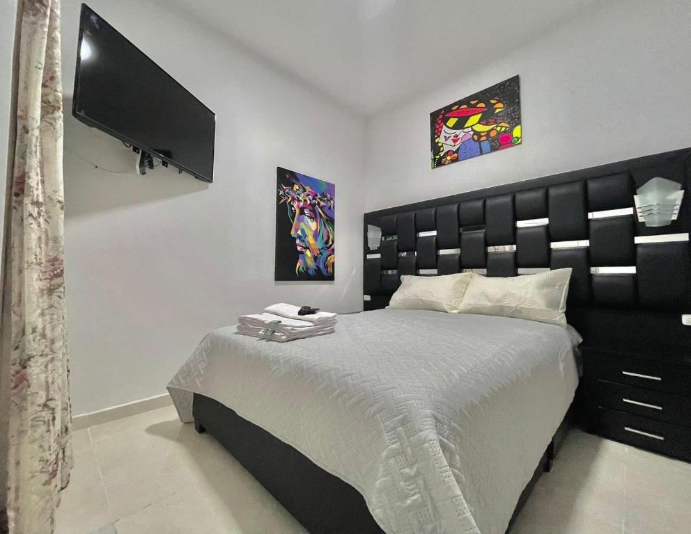a bedroom with a large bed and a flat screen tv at Montesori Habitaciones estrato 6 atrás del CC campanario in Popayan