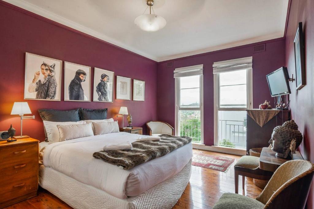 um quarto com paredes roxas e uma cama grande em Great Gatsby Style in the Heart of Double Bay em Sydney