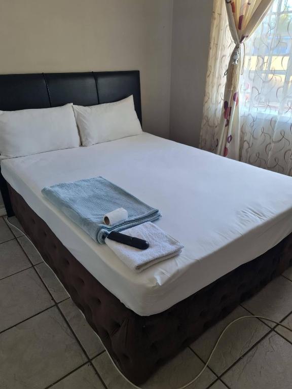 a bed with a knife and a napkin on it at Moon Memories Guesthouse in Welkom