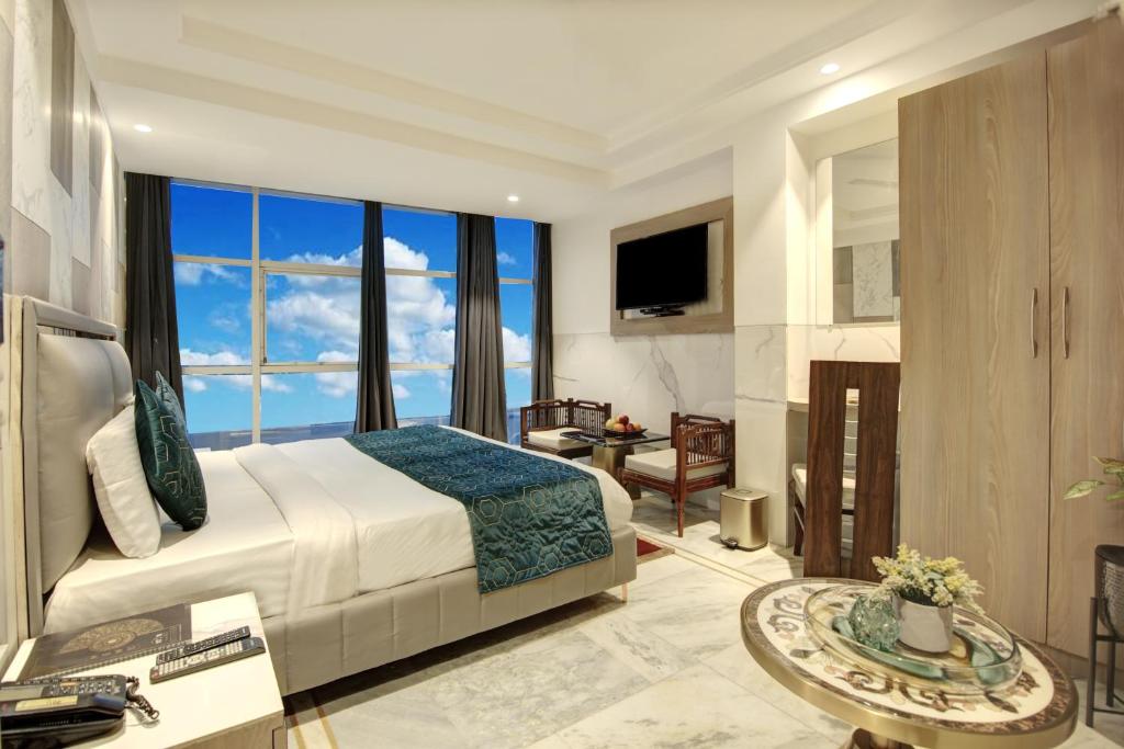Hotel International Inn by Star group - Near Delhi Airport في نيودلهي: غرفة نوم بسرير كبير ونافذة كبيرة