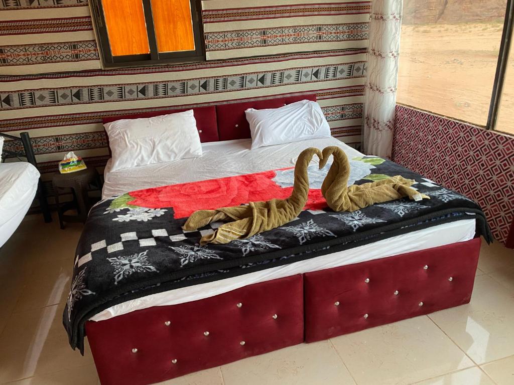 two swans sitting on a bed in a room at Authentic Wadi Rum camp & tours in Wadi Rum