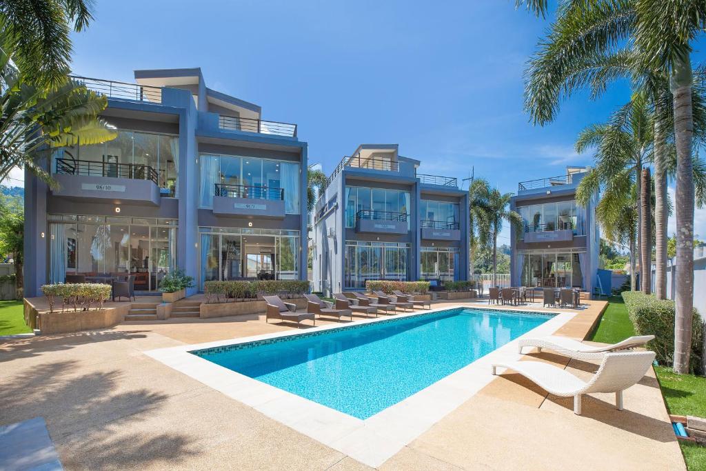 un edificio de apartamentos con piscina y palmeras en 3BR Villa next MissionHills Golf Villa Argent 7 en Ban Muang Mai