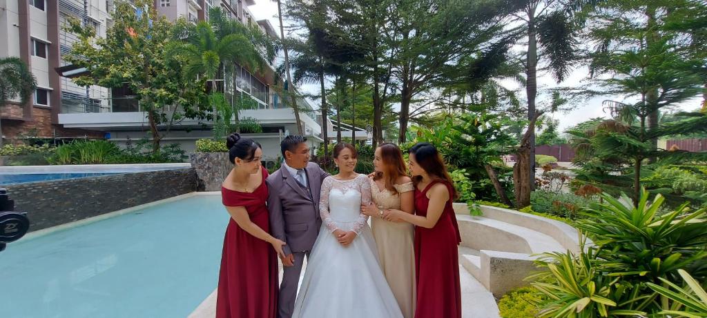 a group of people standing next to a pool at 2bedrooms 2toilet& bath Matina Enclaves Condo in Davao City