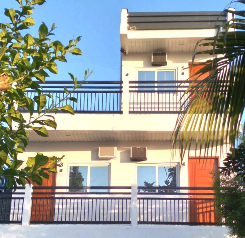 San Carlos的住宿－Riverfront Deluxe Residences，带阳台和橙色门的建筑