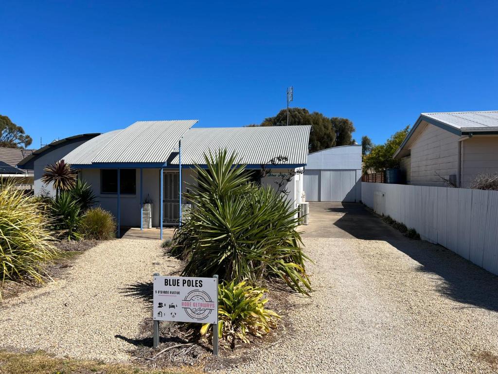 a house with a sign in front of it at Blue Poles - Pet Friendly in Robe