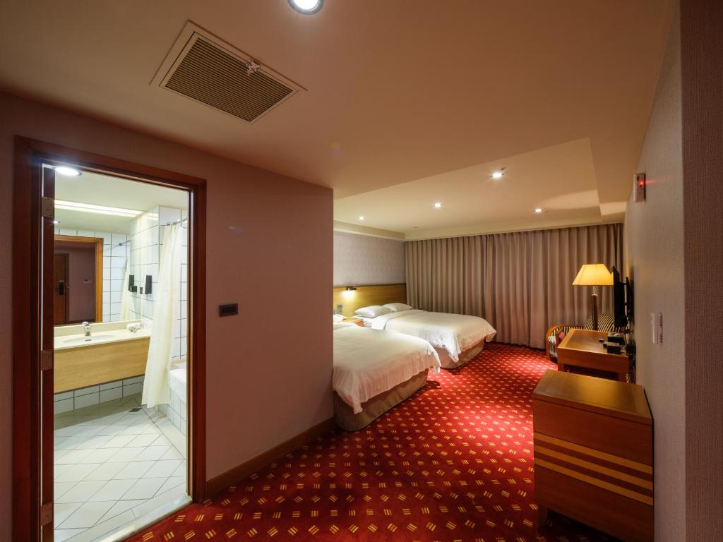 A bed or beds in a room at Rich & Free Hotel - Fuzhong 富逸旅趣-板橋府中館