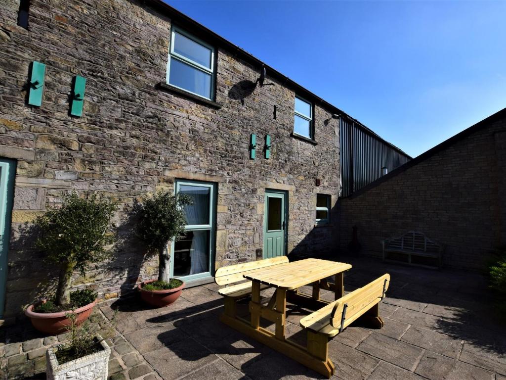 a wooden picnic table in front of a brick building at 4 Bed in Whaley Bridge PK534 in Whaley Bridge