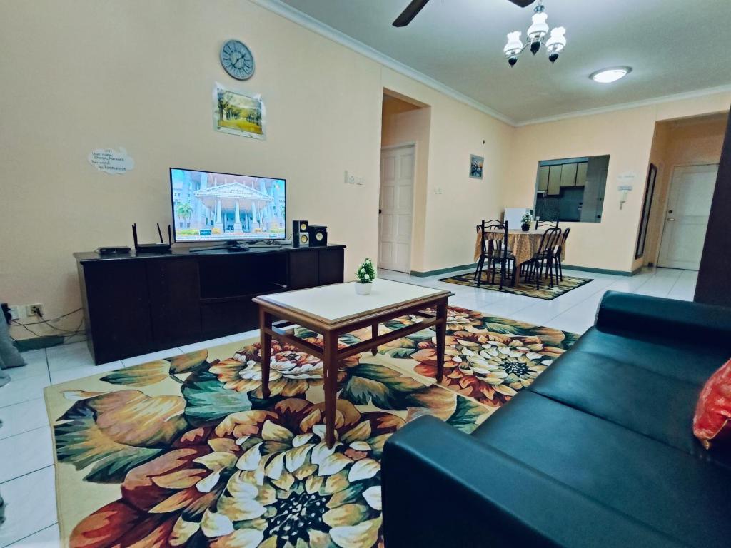 - un salon avec un canapé et une table sur un tapis dans l'établissement Marina Court Resthouse KK, à Kota Kinabalu