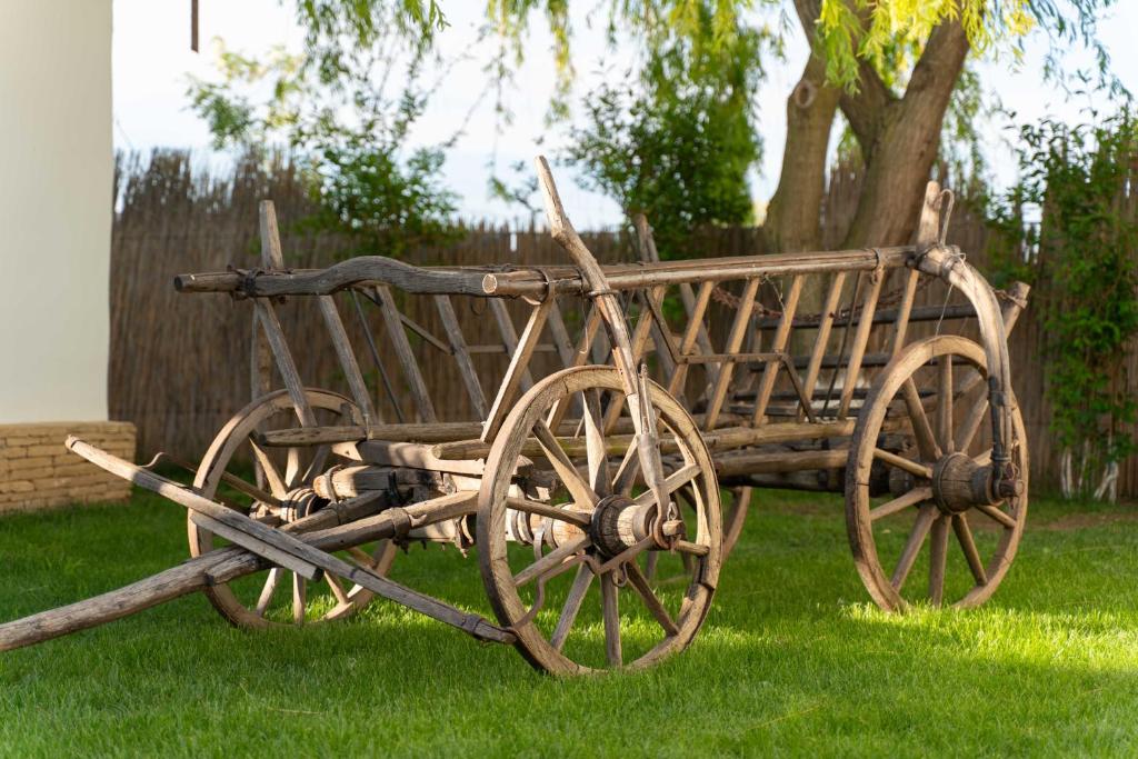 un carrello di legno seduto sull'erba in un cortile di 5 Chirpici - Small Traditional Resort a Murighiol