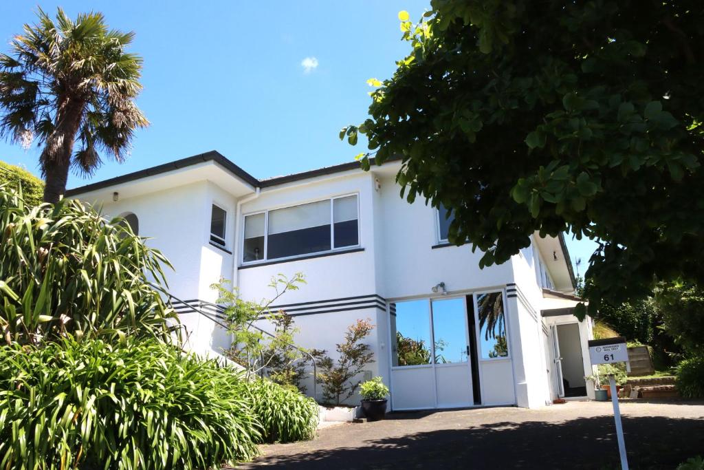 a white house with a lot of windows at Lush, eco, family retreat in Tauranga