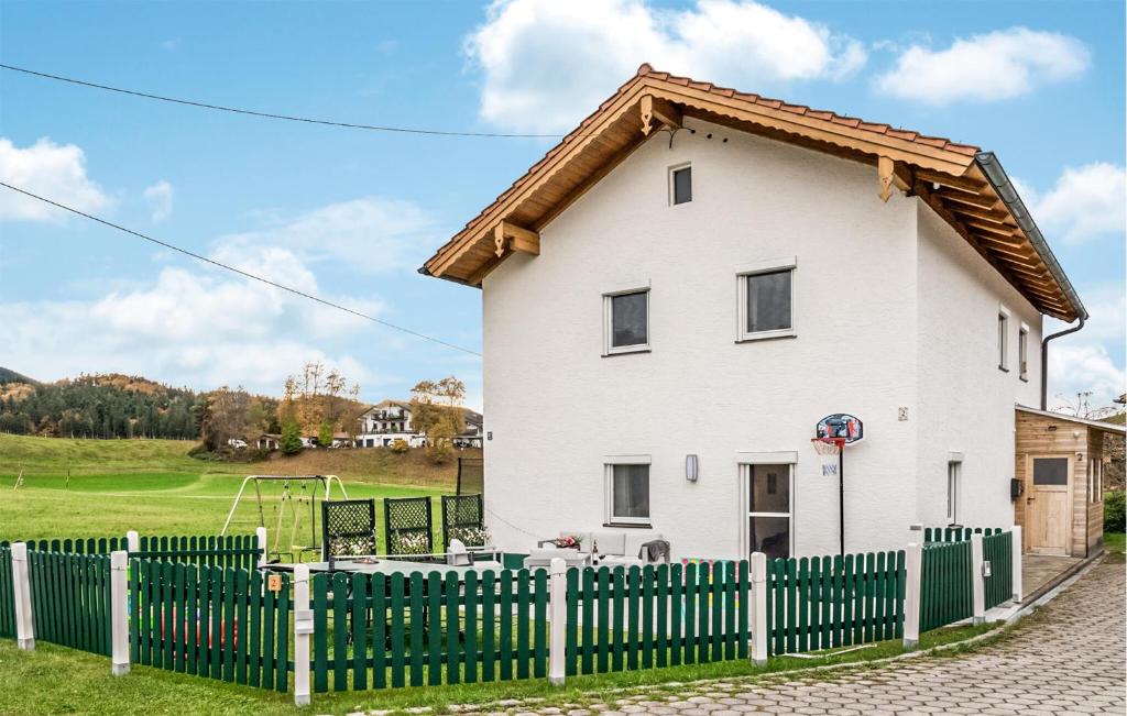 ein weißes Haus mit einem grünen Zaun in der Unterkunft Ferienhaus Bergblick in Gschwend