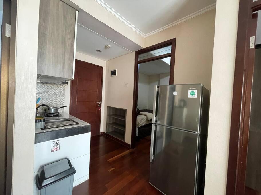 a kitchen with a stainless steel refrigerator in a room at Cozy Apartment 2 bedroom Gateway pasteur Bandung in Bandung