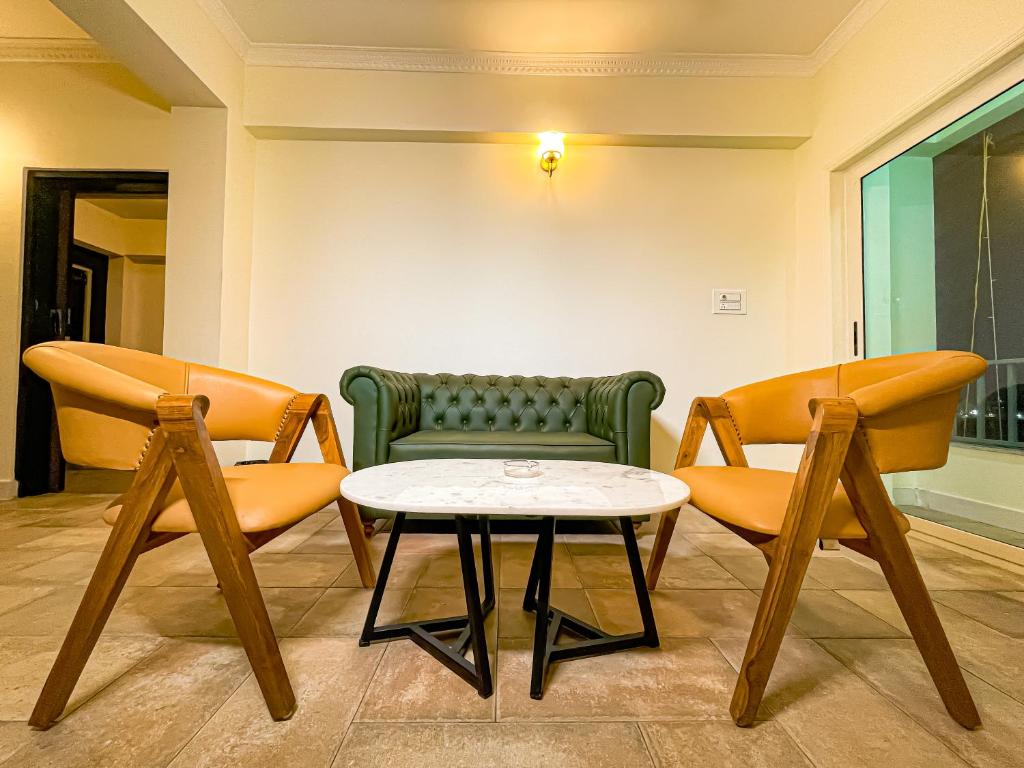 a living room with two chairs and a table at Irroi Guwahati in Guwahati