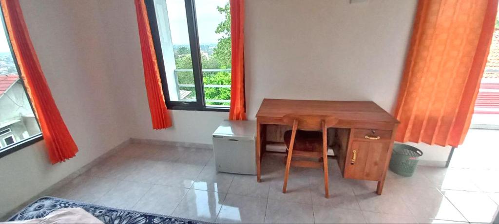 a small table and chair in a room with a window at Chersonese Kost in Alastuwo