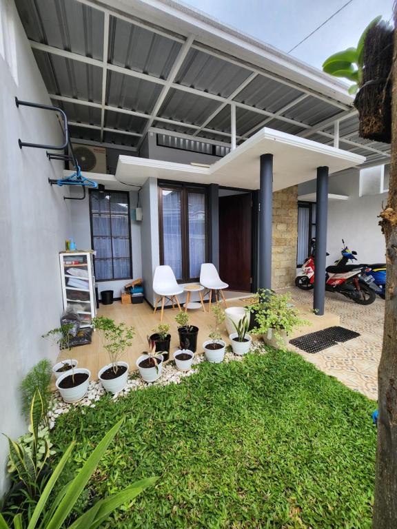 une maison avec des plantes dans une cour dans l'établissement Villa Jingga Joyogrand Malang, à Malang