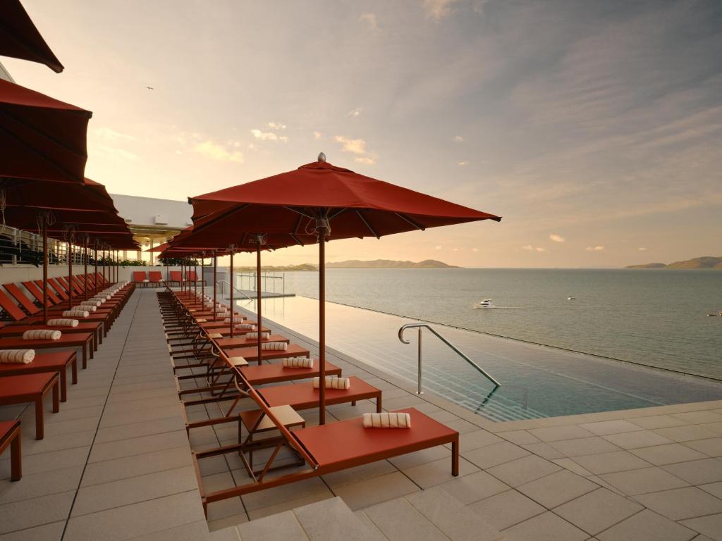 a row of tables and umbrellas next to a pool at Ardo in Townsville