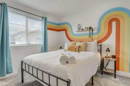 a bed with a rainbow painted on the wall at Spacious-King-SmartTVs-Kitchen-SelfEntry-Townhome in Pikeview