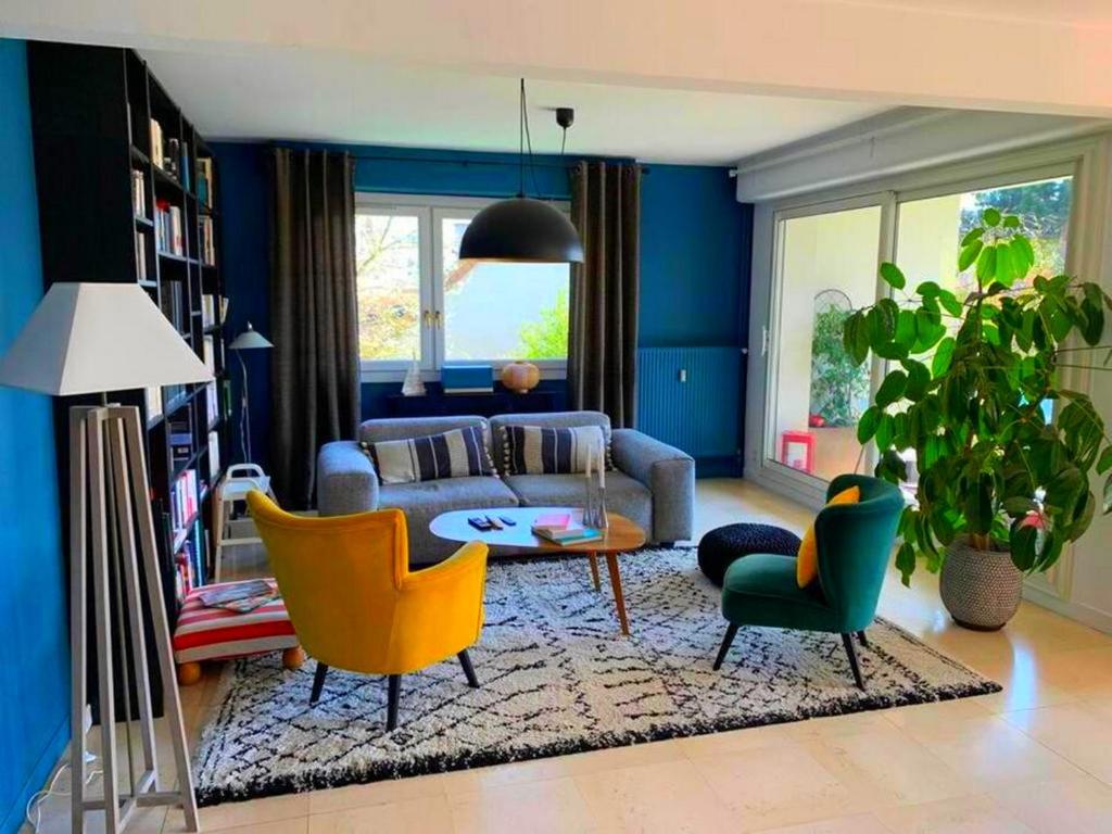 a living room with a couch and a table and chairs at Appartement spacieux, calme et lumineux. in Caen