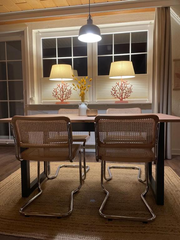 a dining room table with two chairs and two lamps at Loh Apartments - Wald.Natur.Ruhe. in Undeloh