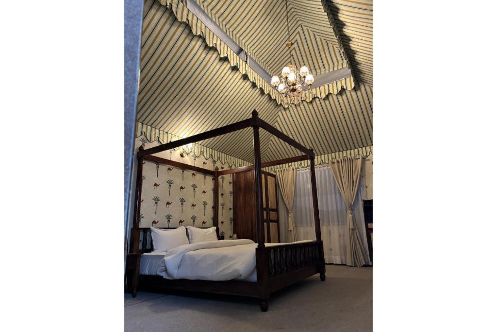 The Grand Shekhawati في Rāmsir: غرفة نوم مع سرير المظلة مع الوسائد البيضاء