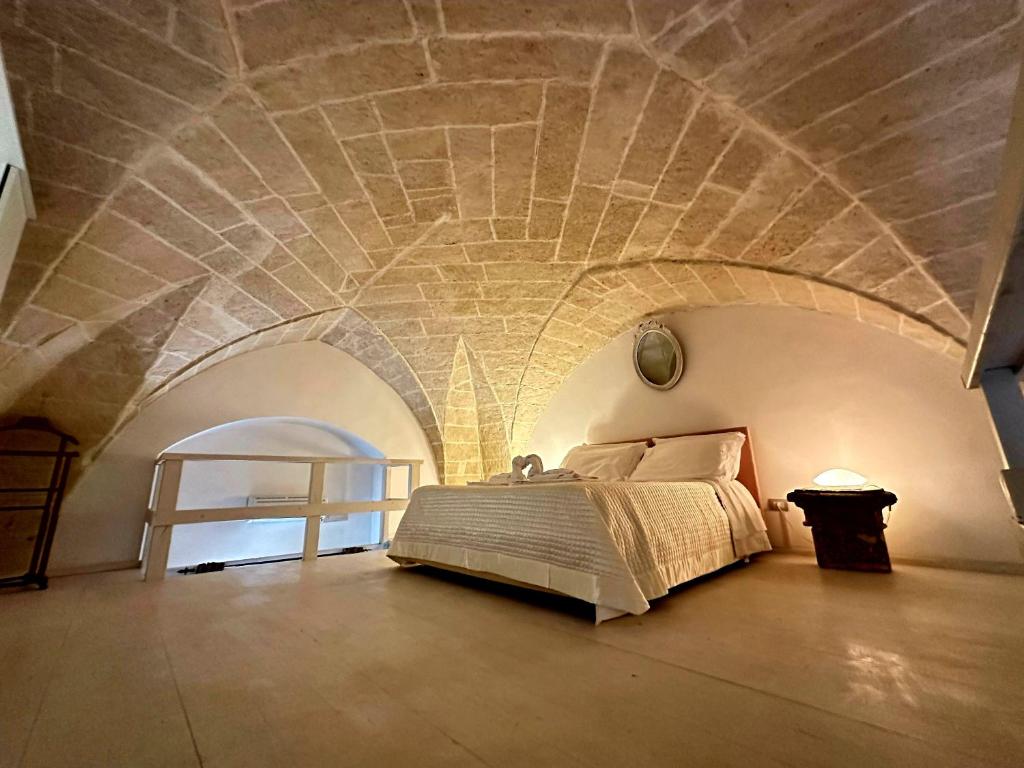 LE DIMORE CENTRO في غالّيبولي: غرفة نوم مع سرير بسقف حجري