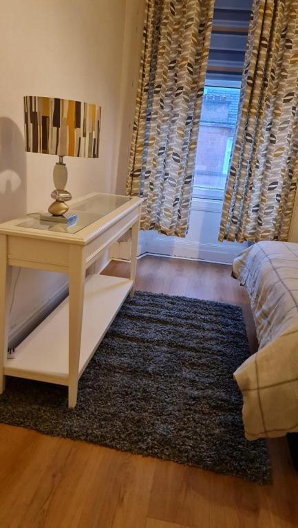 a bedroom with a desk and a bed and a window at Regent Apartments - Glasgow City in Glasgow