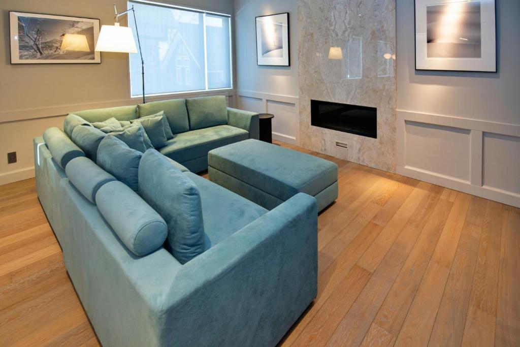 a living room with a blue couch and a fireplace at Shirokuma Chalets in Kutchan